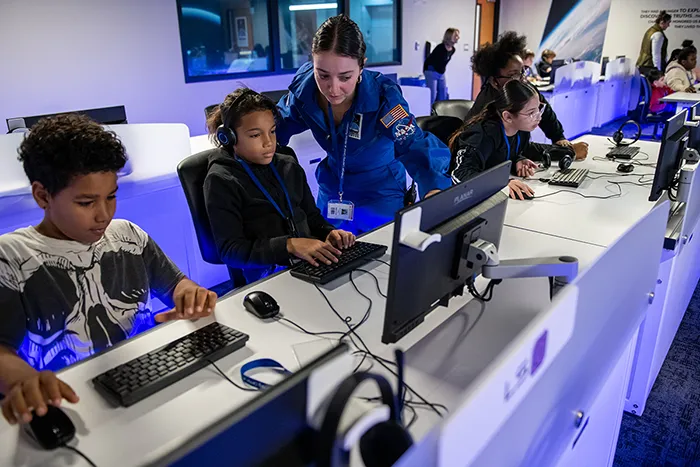 Middle school students participate in a Mission Control simulation as a Challenger Learning Center instructor assists them. Image courtesy of Challenger Center.