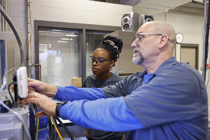 Hawkeye Community College instructor James Konrardy teaches HVAC student Aleese Stewart about geothermal water furnace maintenance during a learning lab in early February  CHRIS ZOELLER, Courier Staff Photographer